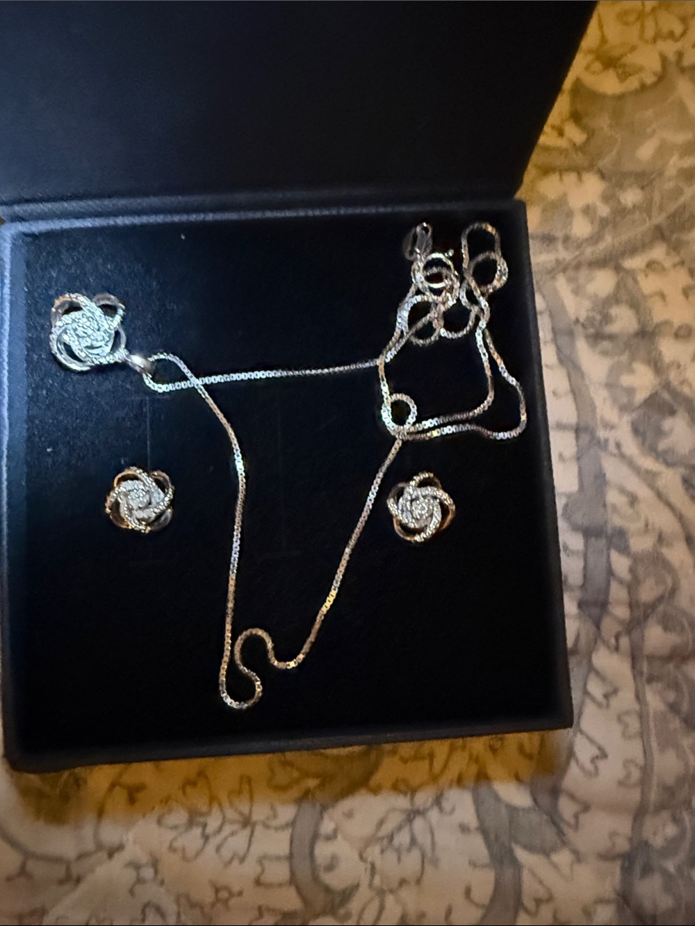 Sterling silver love knot necklace and earring set with cubic zirconia accents.